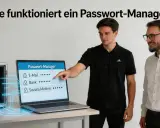 Zwei Männer erklären, wie funktioniert ein Passwort-Manager. Ein Tresor mit Passwortkarten und ein Laptop zeigen die sichere Speicherung.