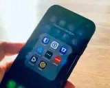 Hand hält Smartphone mit Ordner "Passwort Manager". Darin Apps wie 1Password, Enpass, Dashlane, Keeper – jede eine Bitwarden Alternative.