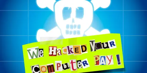 Bedrohlicher Totenkopf über einer Nachricht aus Zeitungsausschnitten: "We Hacked Your Computer PAY!". Ein klares Zeichen für Malware und Ransomware.