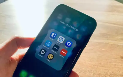 Hand hält Smartphone mit Ordner "Passwort Manager". Darin Apps wie 1Password, Enpass, Dashlane, Keeper – jede eine Bitwarden Alternative.