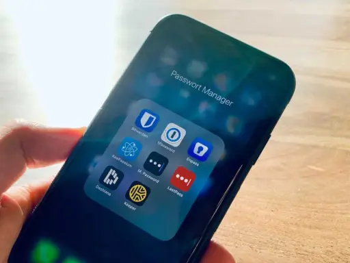 Hand hält Smartphone mit Ordner "Passwort Manager". Darin Apps wie 1Password, Enpass, Dashlane, Keeper – jede eine Bitwarden Alternative.