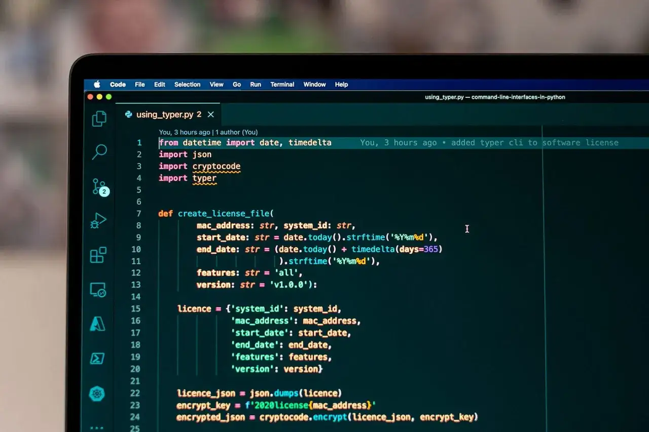 Python-Code auf einem Laptop-Bildschirm, der eine Funktion zur Erstellung von Lizenzdateien mit dem `typer` CLI-Tool zeigt.